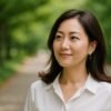 自然の中で落ち着いた笑顔を浮かべる40代の日本人女性が自信に満ちた表情を見せている様子