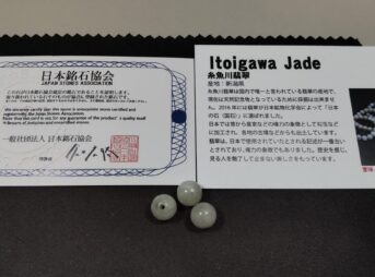 糸魚川翡翠として購入した丸玉3粒と日本銘石協会の証明書、ストーン説明カード