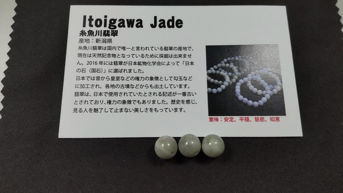 糸魚川翡翠とは?特徴・歴史・国石になった理由をわかりやすく解説 糸魚川翡翠のストーン説明カードと筆者が購入した淡い緑色の丸玉3粒
