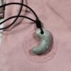 淡い緑色をした糸魚川翡翠の勾玉を近くから撮影した様子