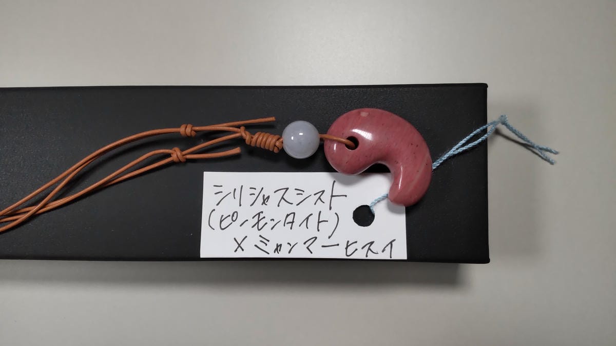 運営者プロフィール ピンク色の勾玉と石名が記された購入時の手書きラベル