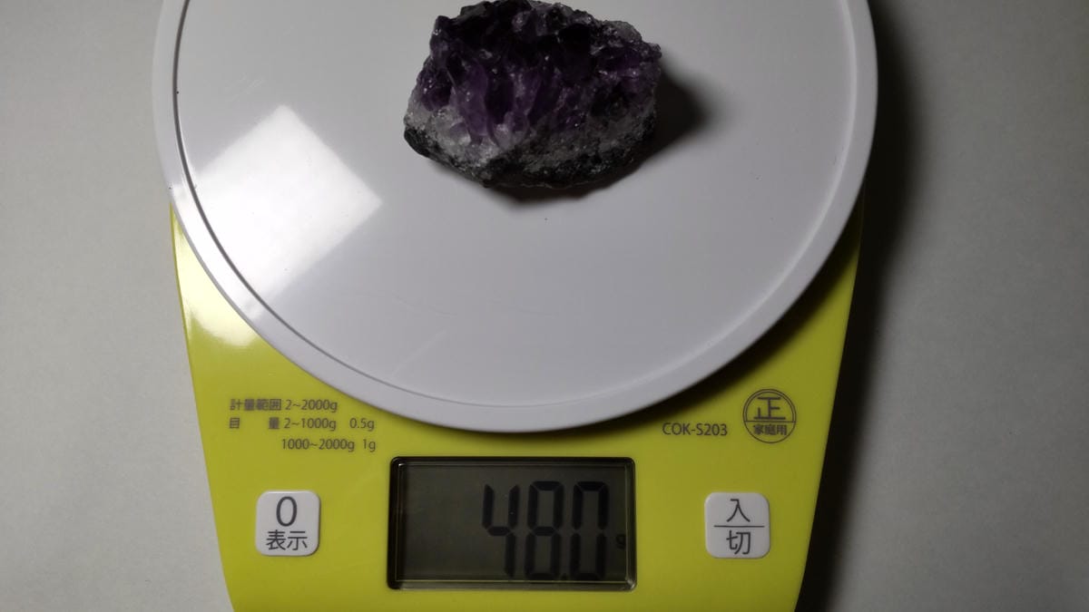 アメジストクラスターを家庭用計量器に載せ、重量が48.0gと表示されている写真