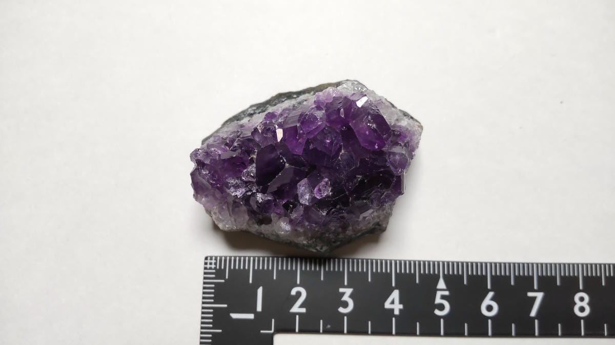 小型アメジストクラスターを定規と並べた写真。横幅がおよそ5cm前後であることが分かる