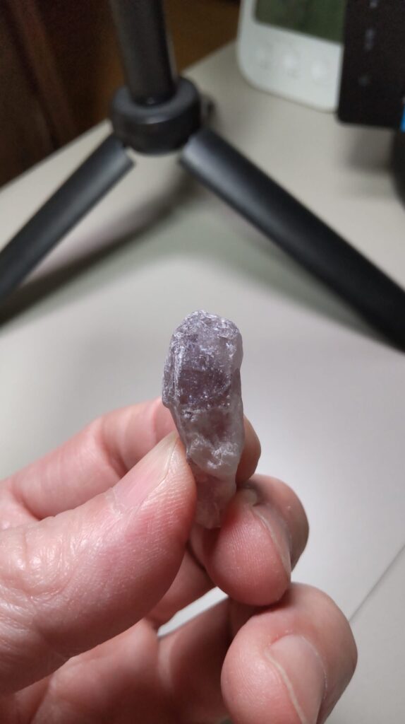 歯ブラシで表面を清掃した後のポイント状アメジスト原石。紫色の面と残っている白っぽい部分