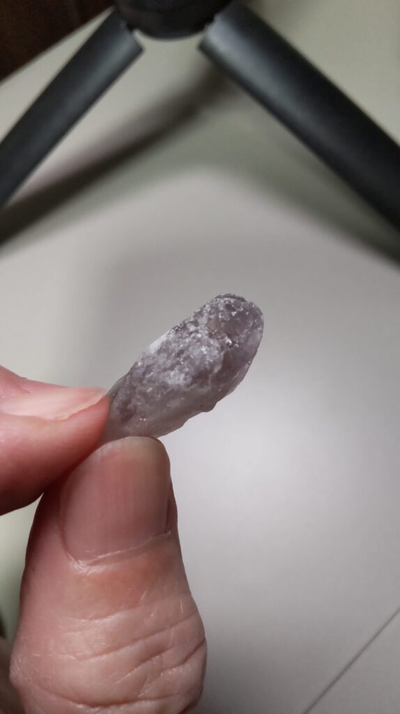 水洗い後のポイント状アメジスト原石。紫色の表面と一部に残る白っぽい部分が見える