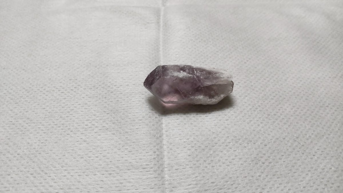 細長いアメジスト原石の側面に見える、淡い紫色の透けた部分と白っぽい部分